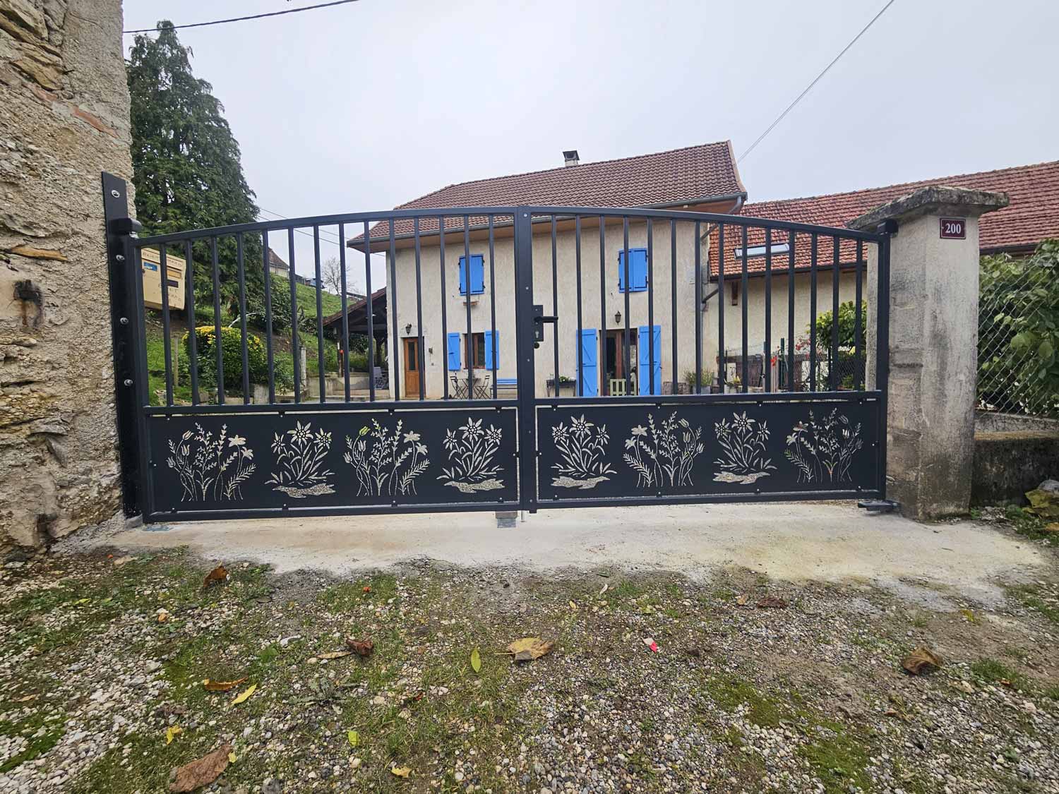 Photo d'un portail en métal gris avec gravures de fleurs