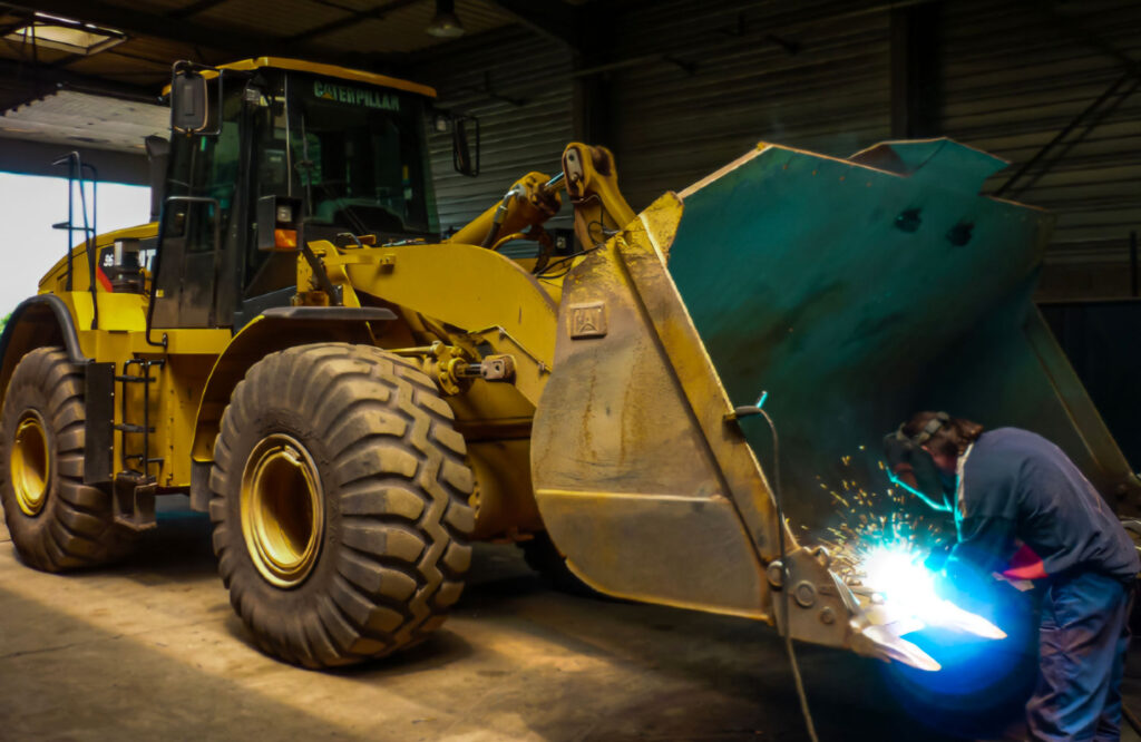 Photo d'un soudeur entrain de réparer un engin agricole